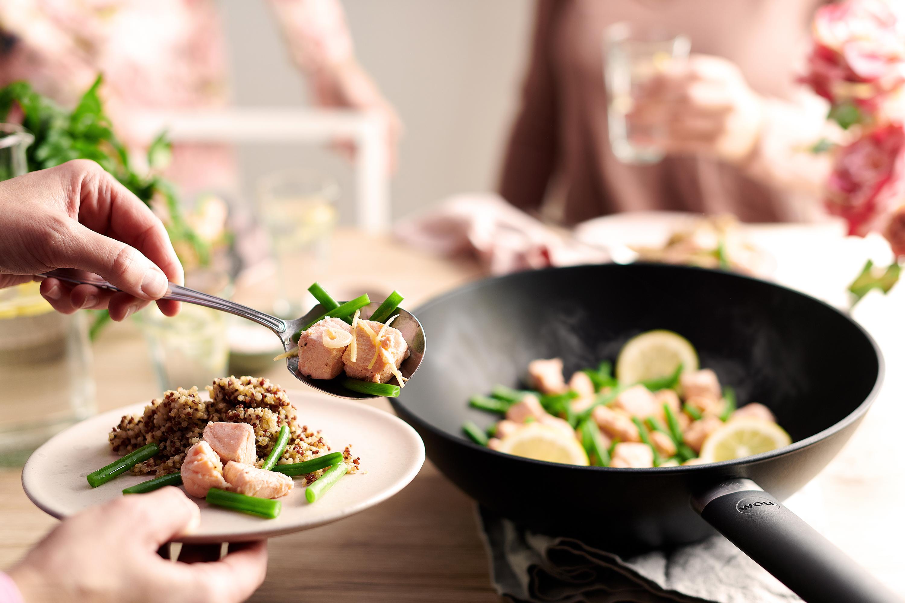 Eco Lite QXR Wok In einer Eco Lite QXR Wok- und Rührpfanne wird Lachs mit grünen Bohnen zubereitet und auf einem Teller platziert.