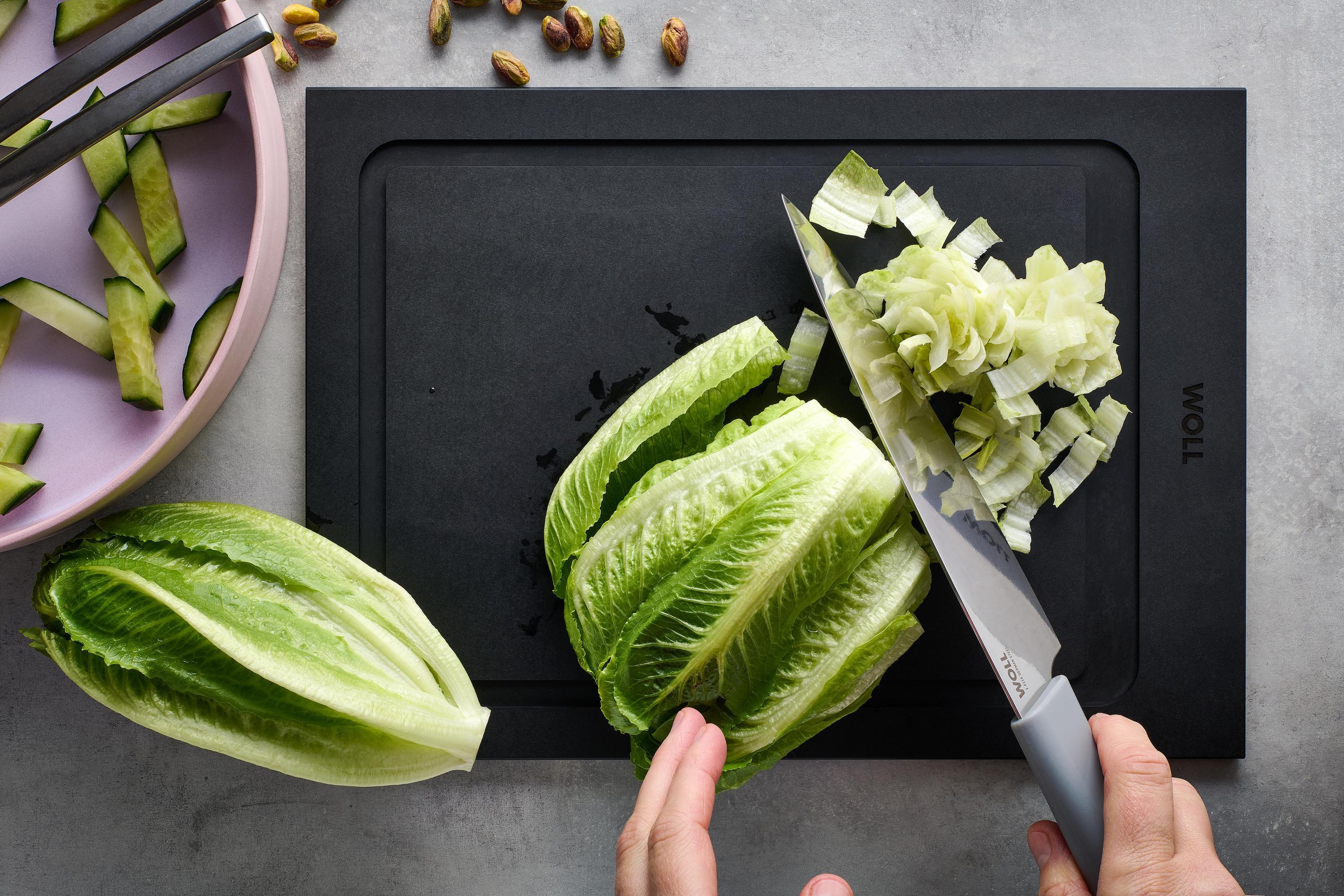 Cutting Edge Kochmesser Auf einem Cut & Serve Schneidebrett wird mit einem Cutting Edge Messer Salat klein geschnitten.