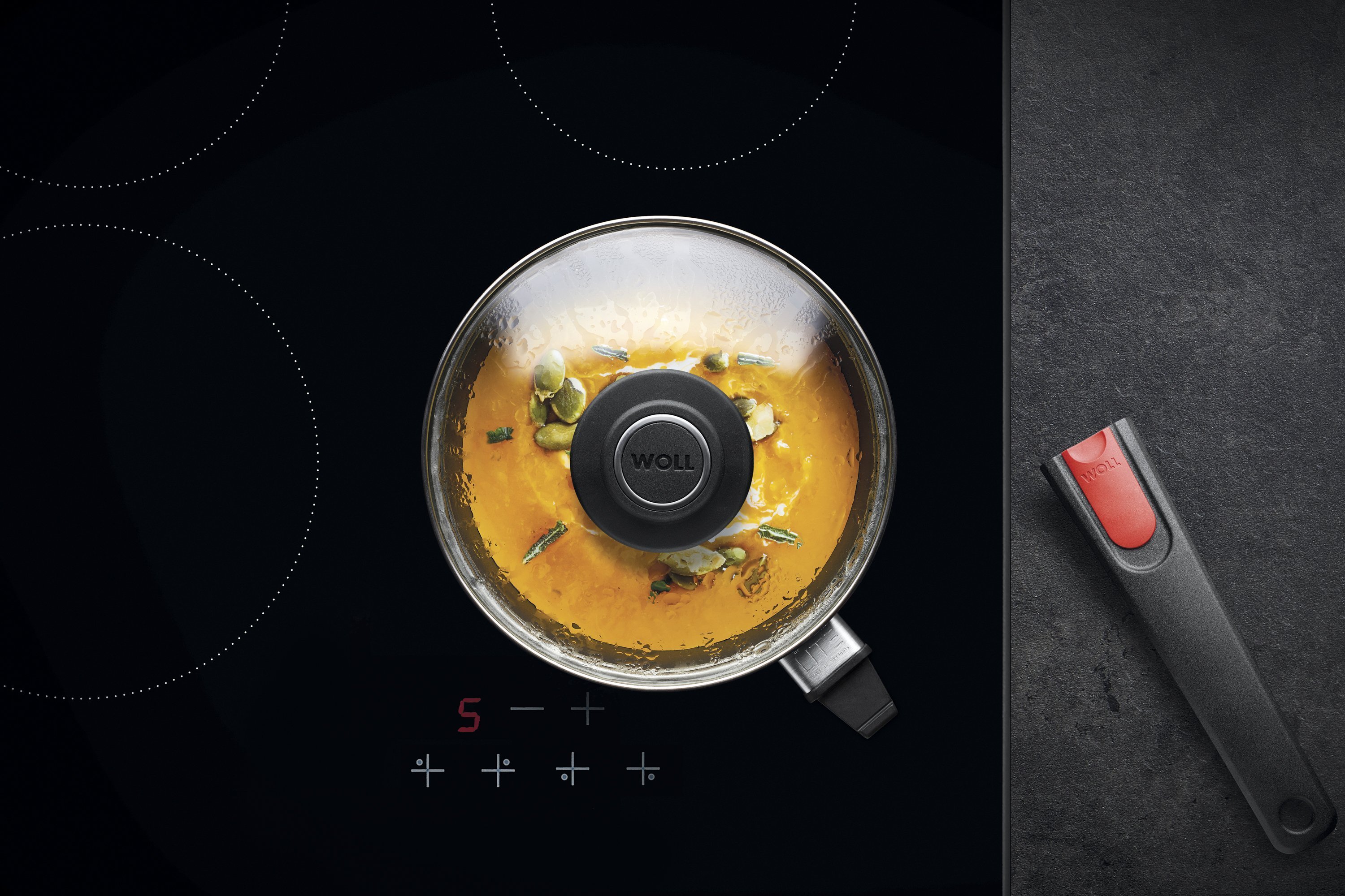 Auf dem Herd steht eine runde Diamond-Lite-Pfanne mit abgenommenem Stiel, in der ein Gericht zubereitet wird. Am Glasdeckel hat sich Kondenswasser gebildet.