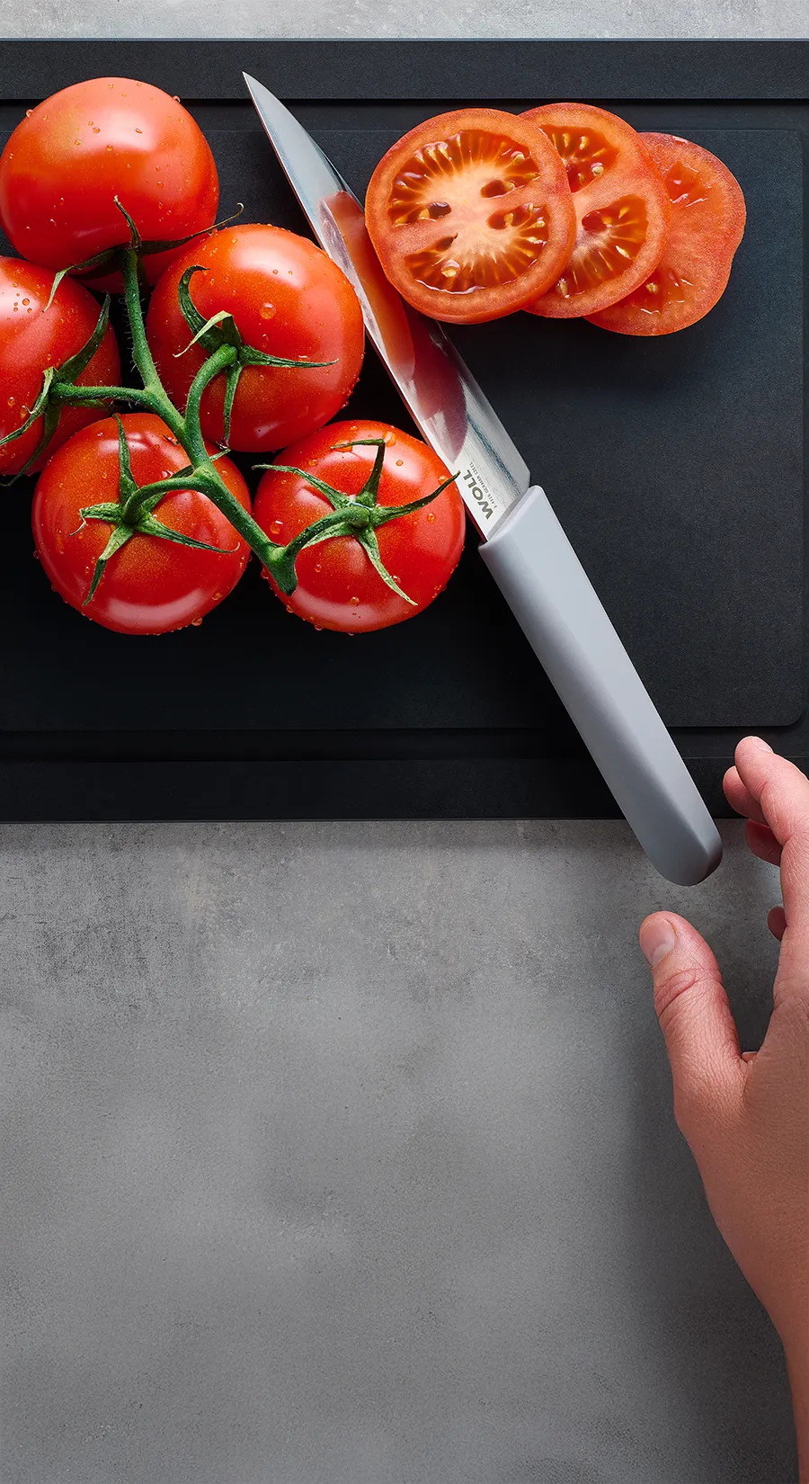 Mit dem Messer der Serie Cutting Edge werden Cherrytomaten auf einem Schneidebrett der Serie Cut & Serve halbiert.