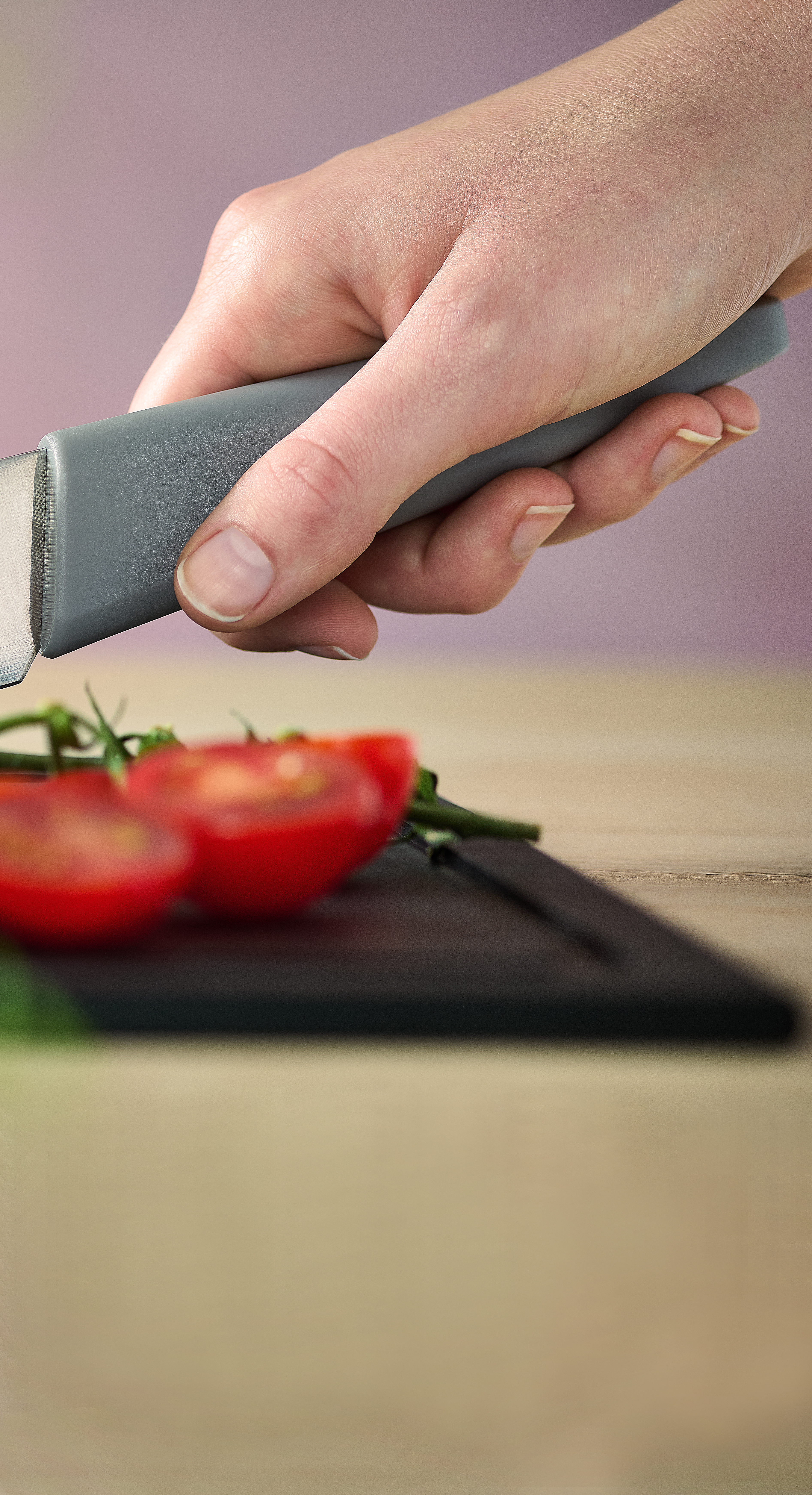 Cutting Edge Steakmesser Mit dem Cutting Edge Messer werden mehrere Cherrytomaten auf einem Cut & Serve Schneidebrett halbiert.