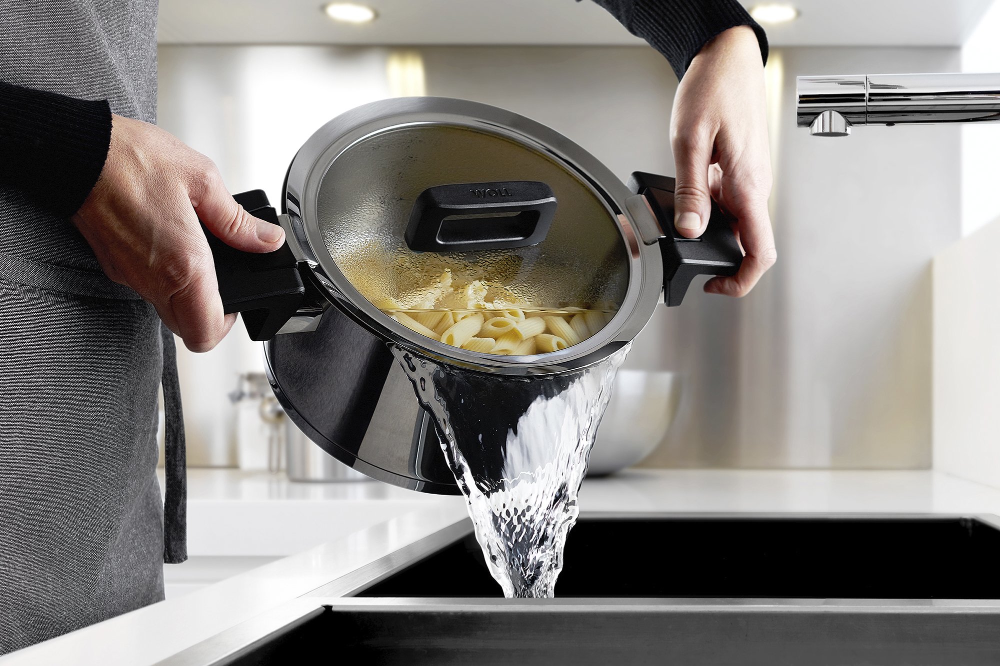 Das Nudelwasser wird aus dem Concept Topf in die Spüle gegossen. Durch die angehobene Position des Glasdeckels ist ein sicheres Abgießen möglich.
