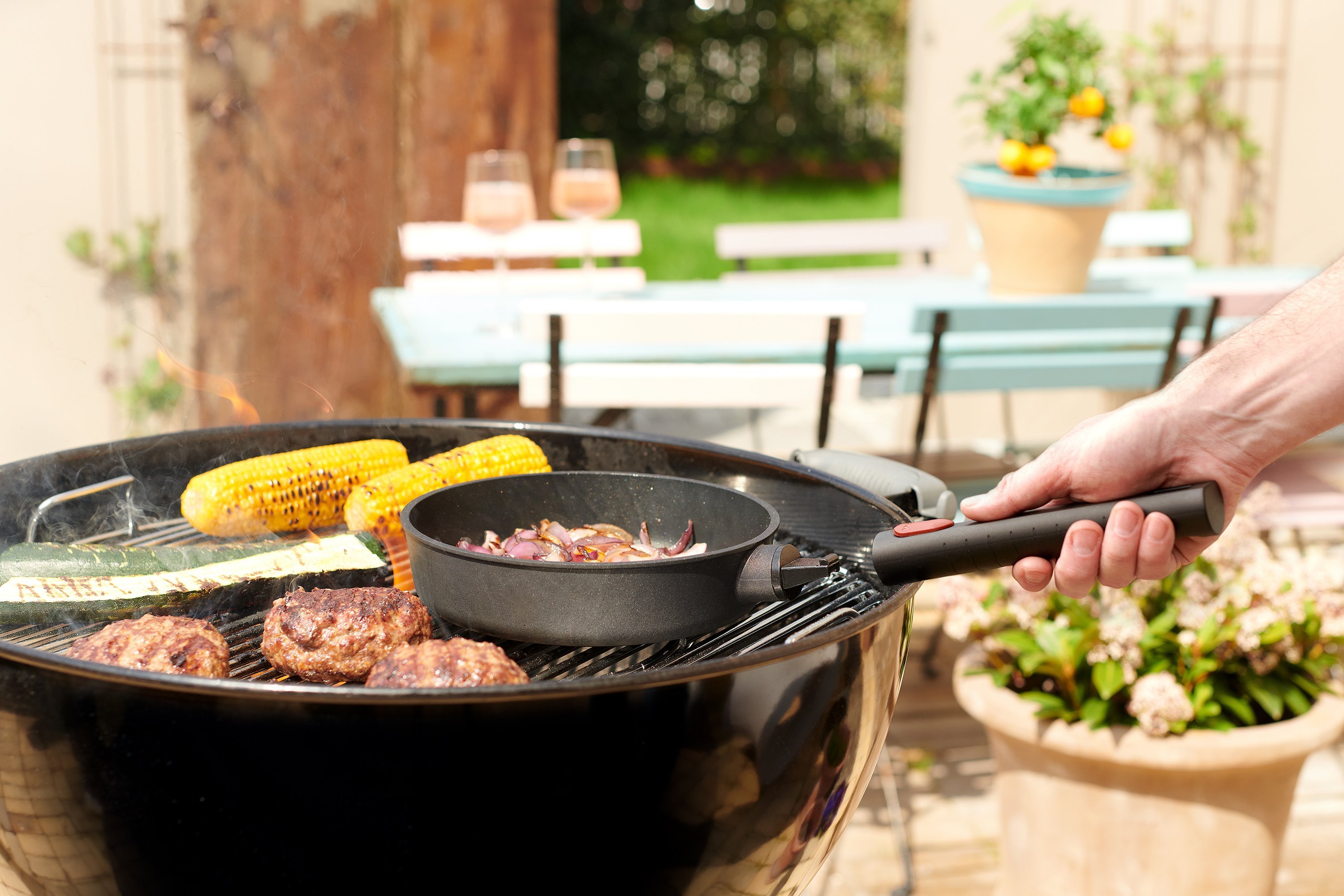 Auf dem Grill steht eine runde, gefüllte Logic XR Pfanne mit abgenommenem Stiel. 