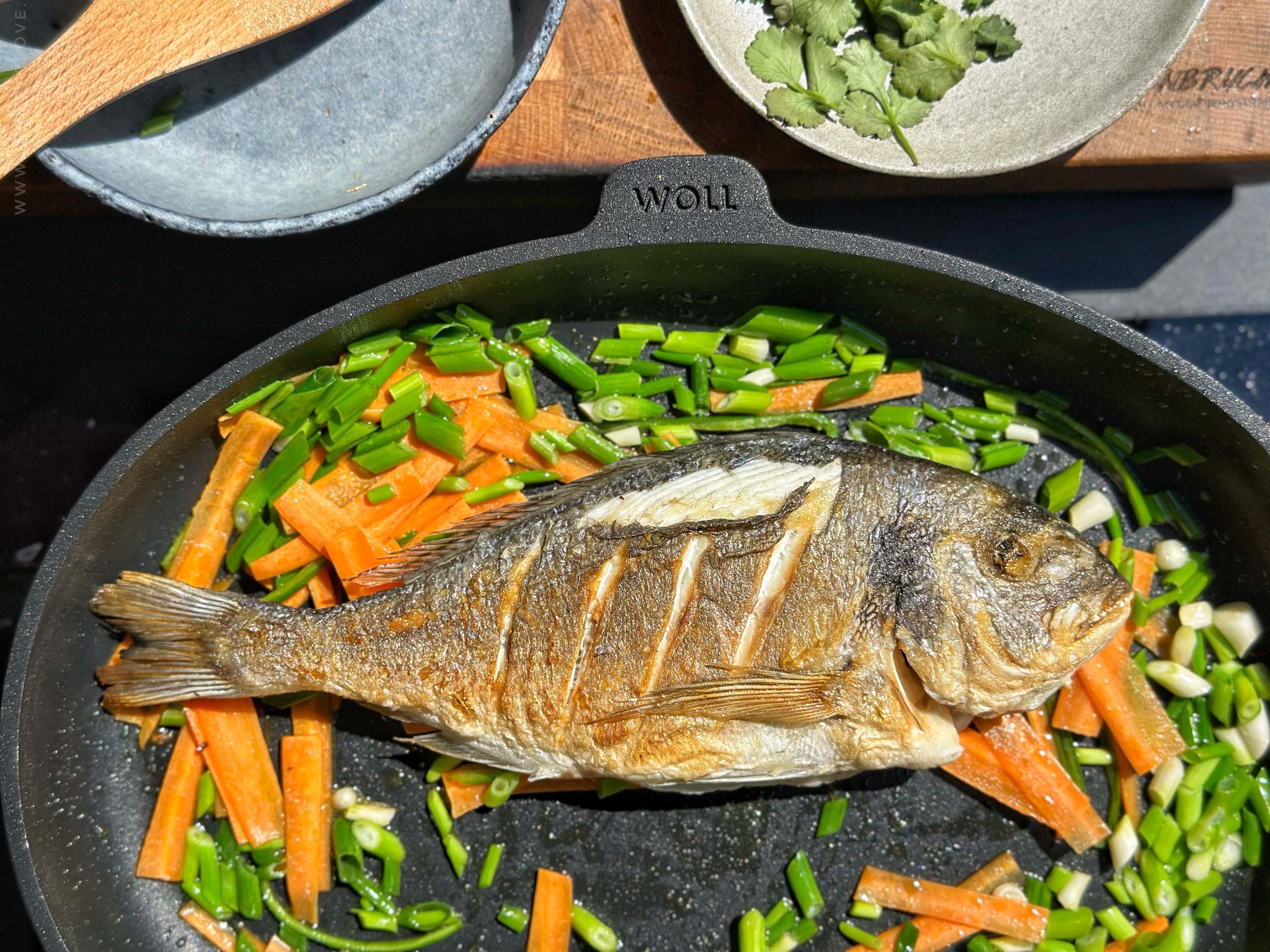 In einer runden Titan Best Pfanne wird ganzer Fisch angebraten.