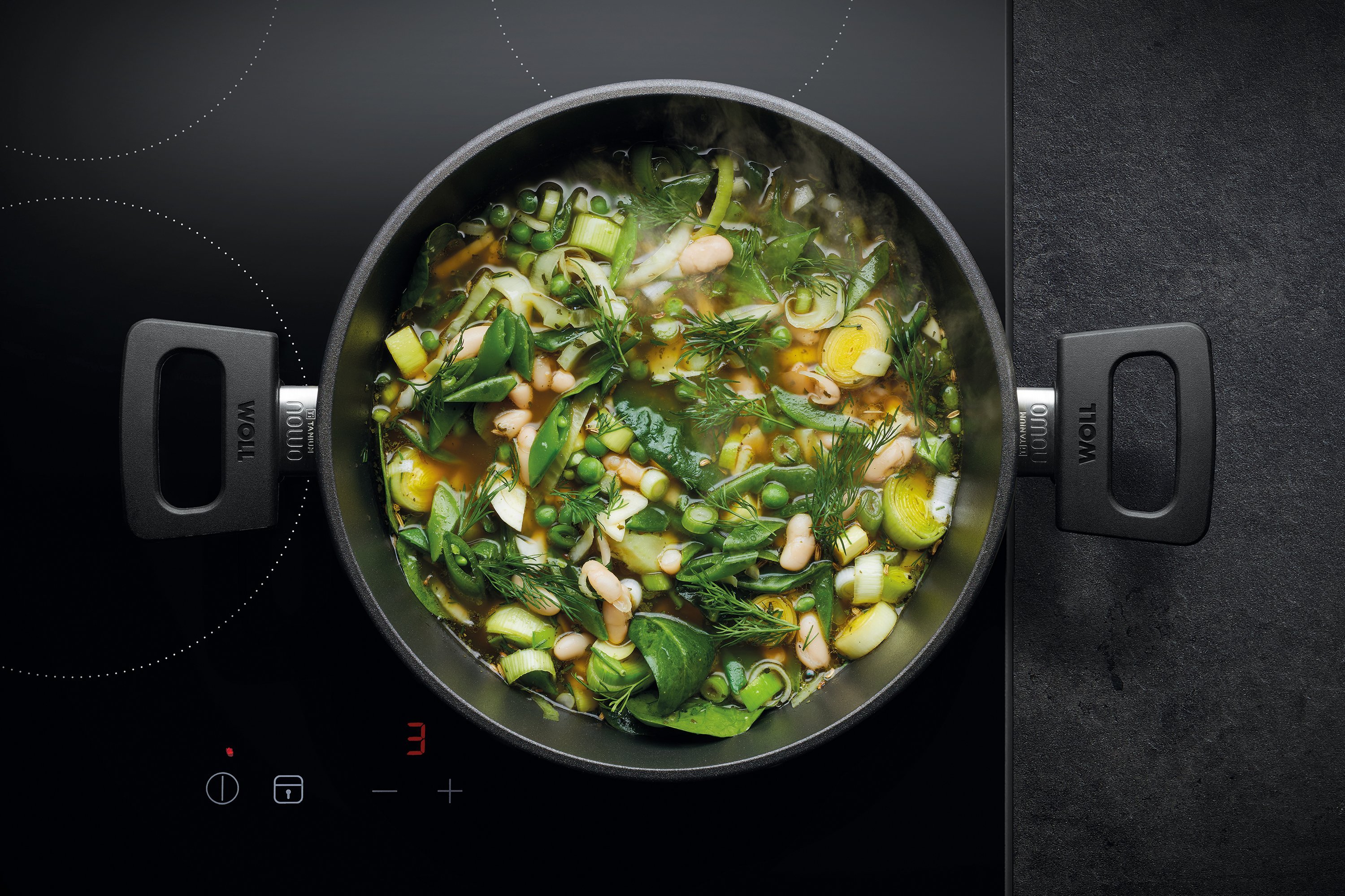 Auf dem Herd steht ein runder, heißer Topf Serie Nowo. Darin befindet sich eine frisch zubereitete italienische Frühlingssuppe.