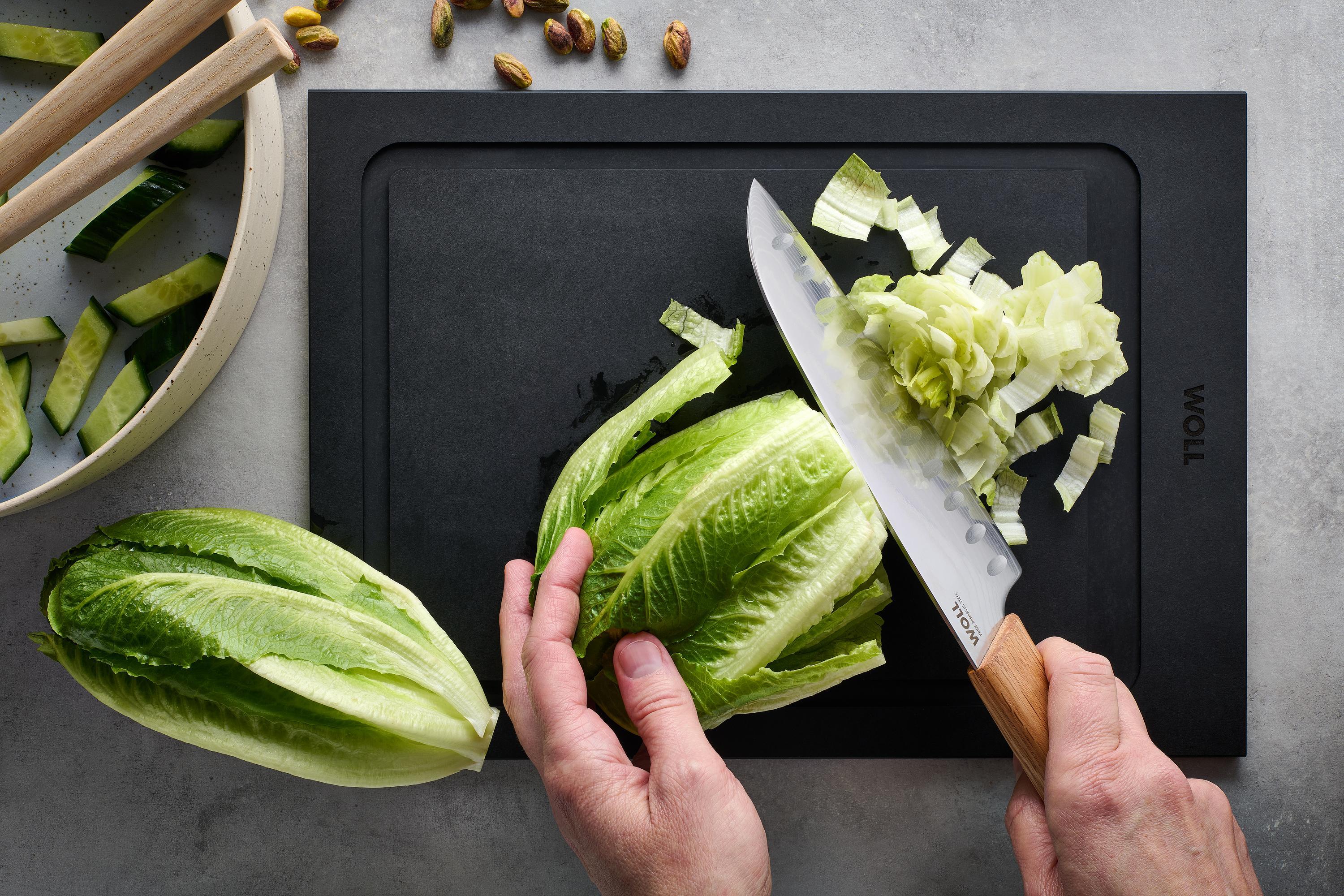 Prime Edge Santokumesser Mit dem Prime Edge Santokumesser wird ein Salatkopf auf einem Schneidebrett kleingeschnitten.