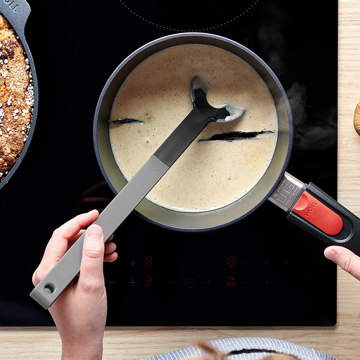 Cook it Lochlöffel In einem runden Diamond Lite Stieltopf wird Vanillesauce gekocht und mit einem grauen Cock it Lochlöffel umgerührt.