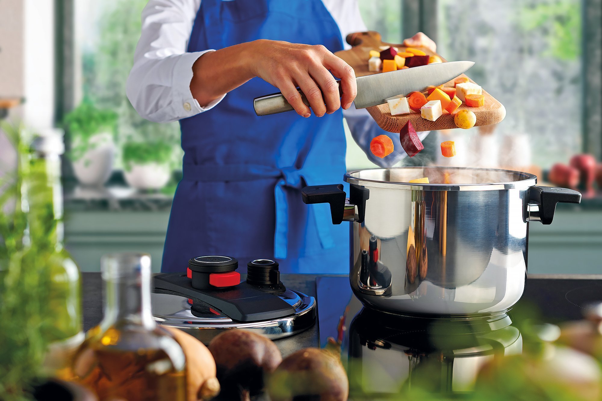 Auf dem Herd steht ein Pressure Pro Schnellkochtopf, in den frisch geschnittenes Gemüse gegeben wird. 