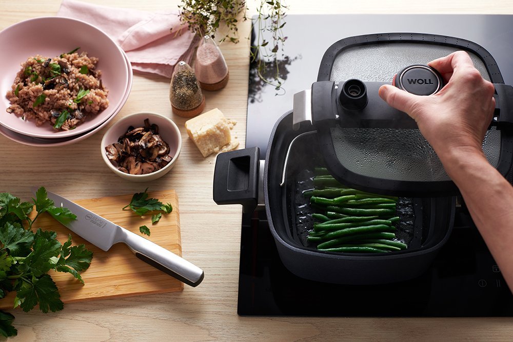 In einer viereckigen Diamond Active Lite Kasserolle mit abgenommenem Glasdeckel werden Bohnen in einem Siebeinsatz gedünstet.