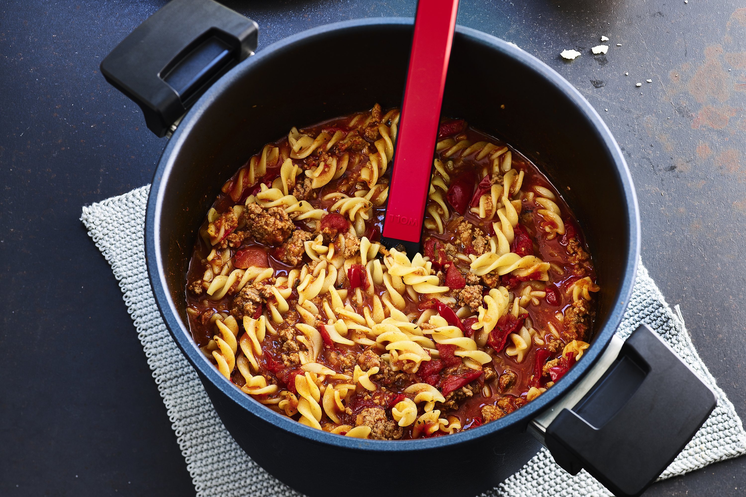 In einem runden Diamond-Lite-Topf befindet sich frisch zubereitete One-Pot-Pasta Bolognese. Mithilfe eines Küchenhelfers kann die Pasta entnommen werden.