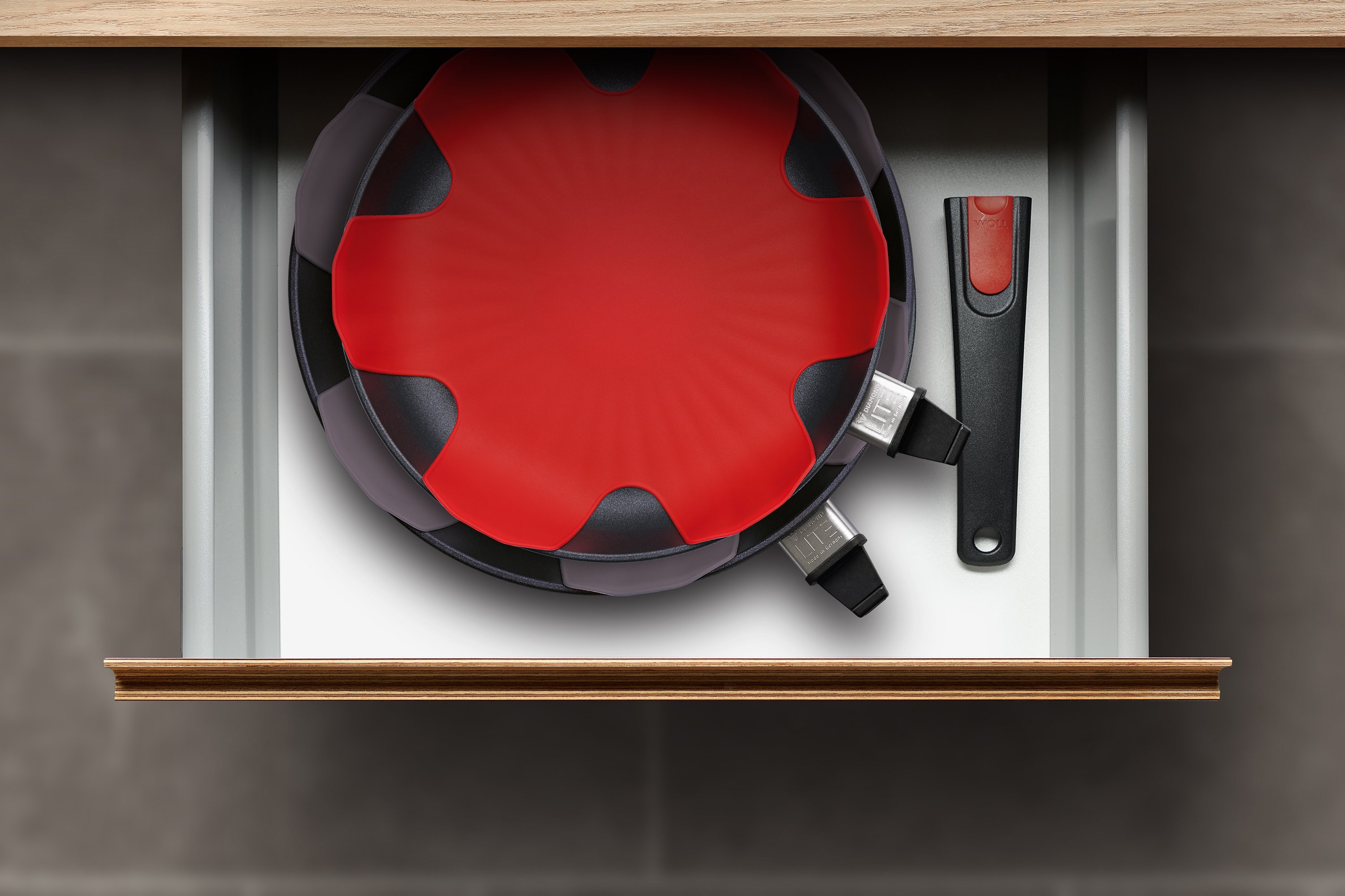 In einer Schublade liegen zwei Diamond Lite Pfannen mit abgenommenem Stiel, mit einem Silikon-Pfannenschutz dazwischen.