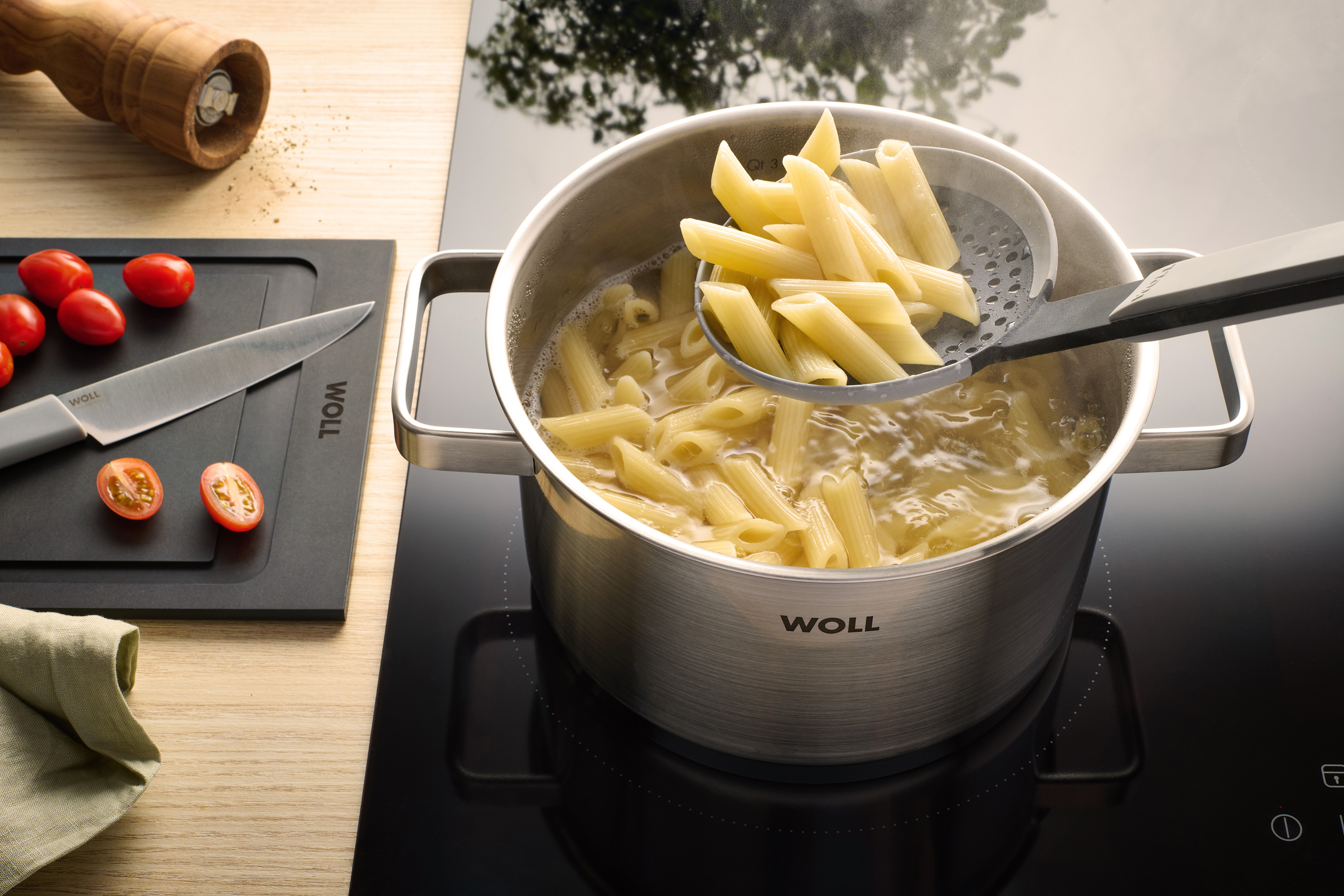 Cook it Schaumlöffel Mit einem Steam it Schaumlöffel werden Nudeln aus einem Steel Topf entnommen.