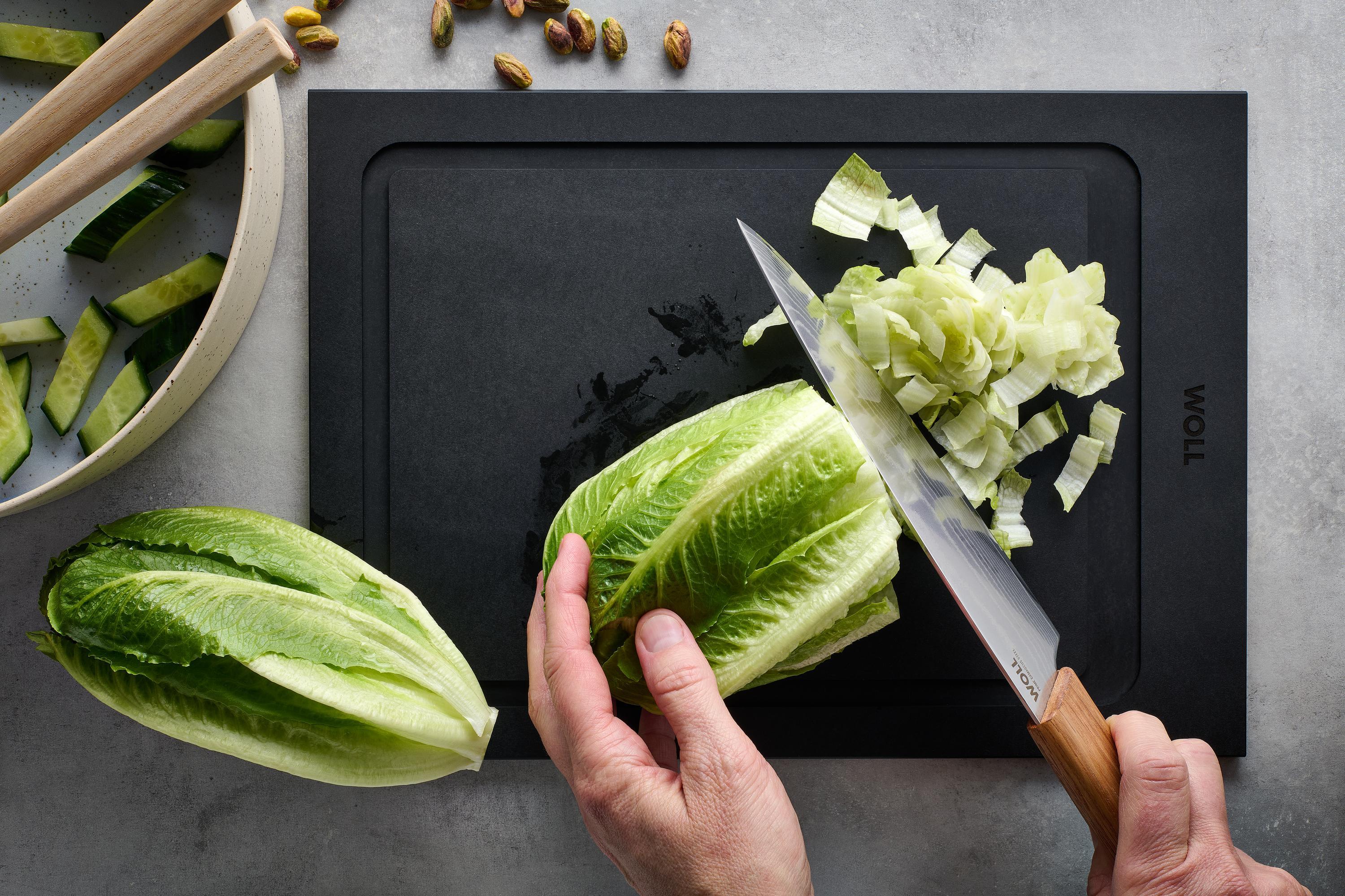 Prime Edge Kochmesser Mit dem Prime Edge Santokumesser wird ein Salatkopf auf einem Schneidebrett kleingeschnitten.
