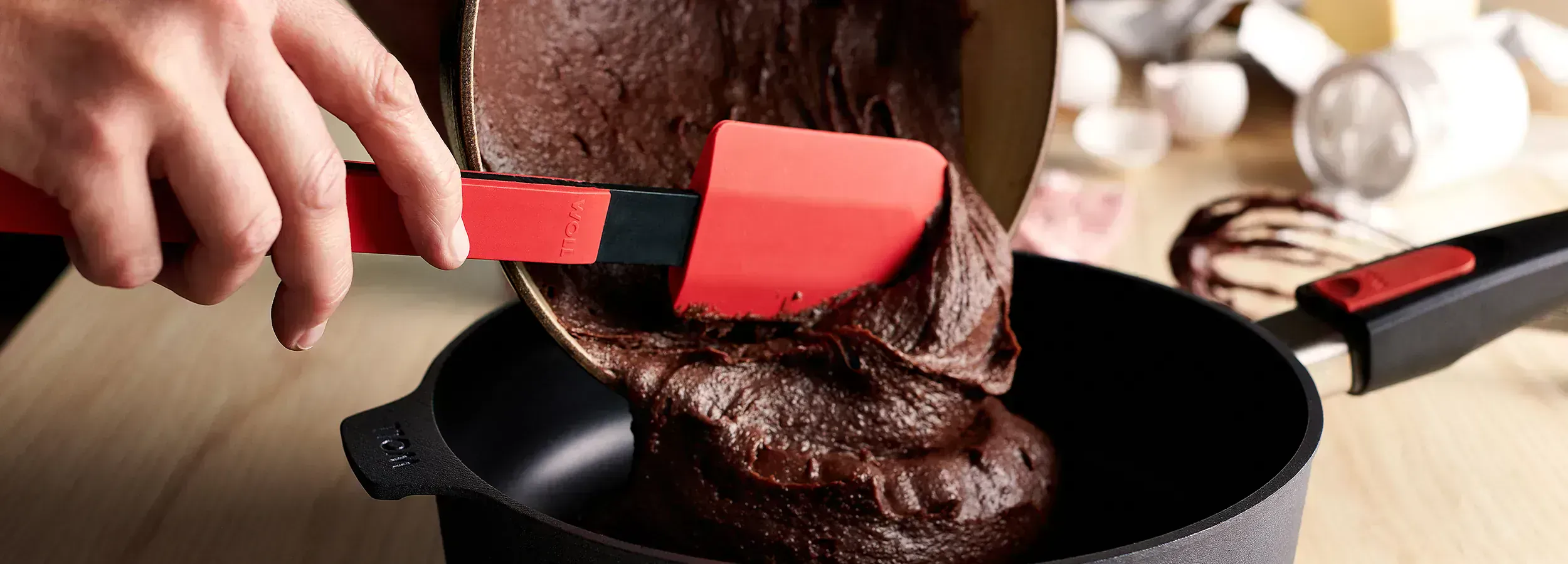 Der Kuchenteig wird mit dem Cook-it-Teigschaber aus der Schüssel direkt in die Diamond Lite Hochrandpfanne gegeben.
