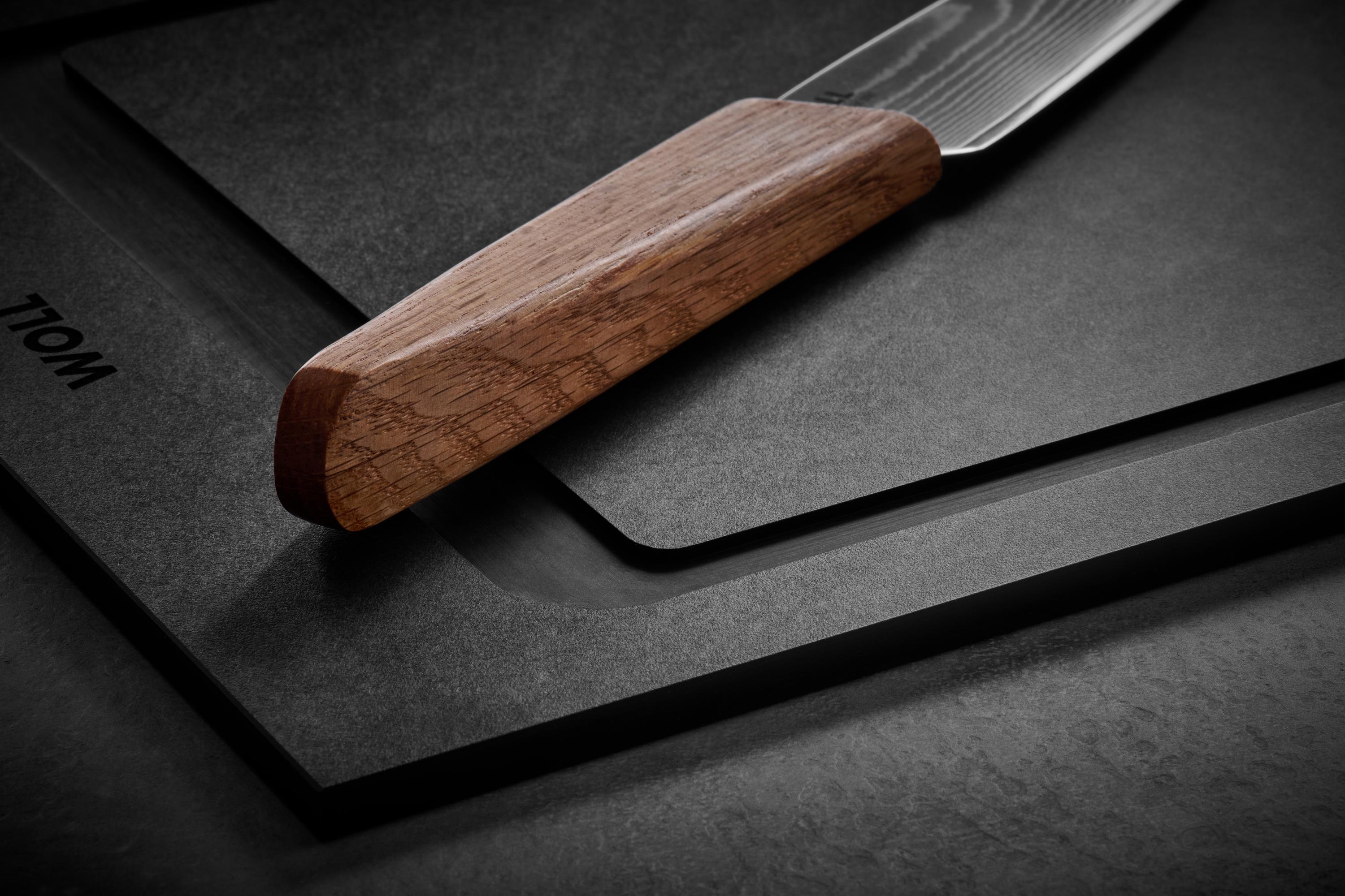 Prime Edge Universalmesser Ein Prime Edge Kochmesser Kompakt liegt auf einem Cut & Serve Schneidebrett.