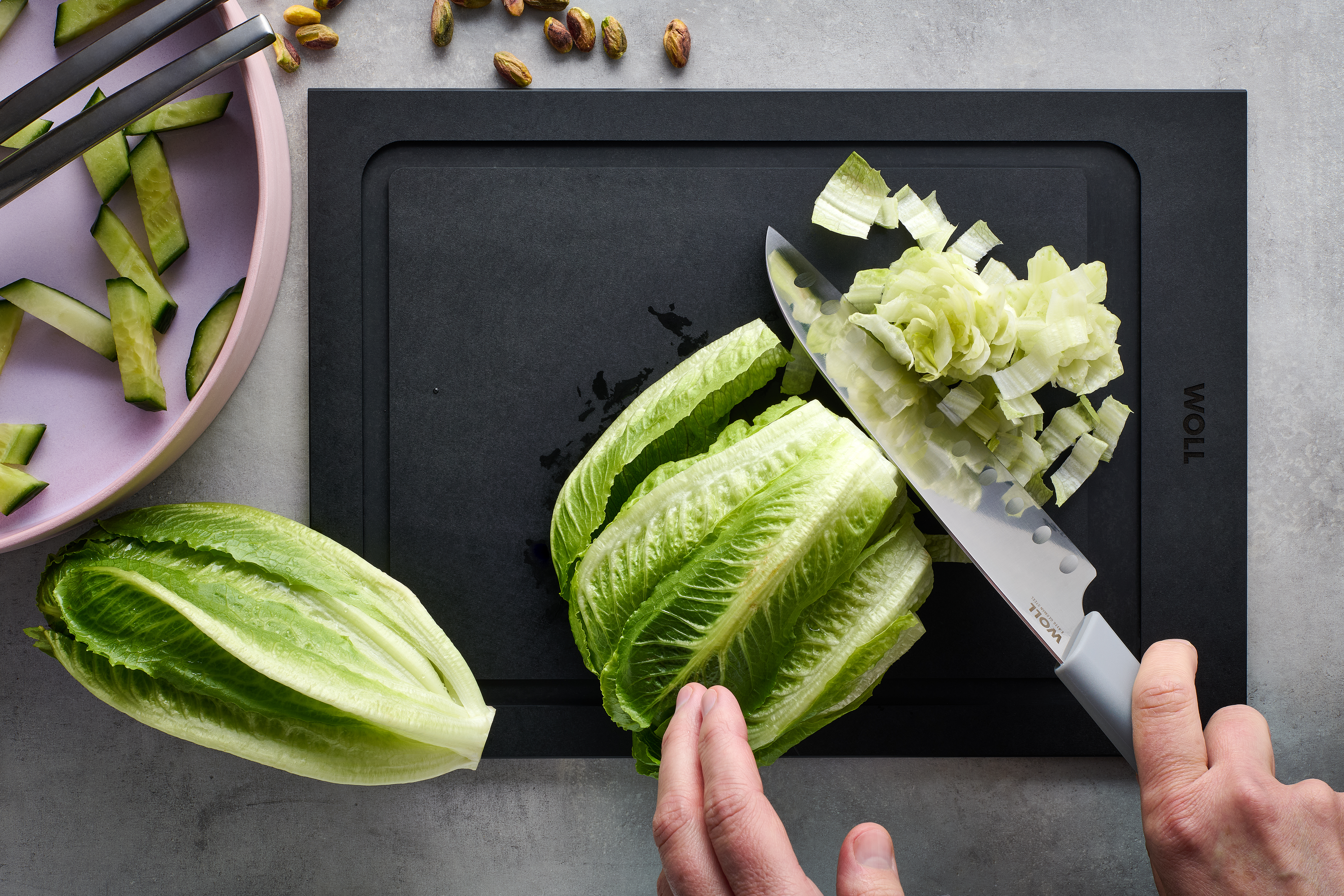 Cutting Edge Santokumesser Auf einem Cut & Serve Schneidebrett wird mit einem Cutting Edge Messer Salat klein geschnitten.