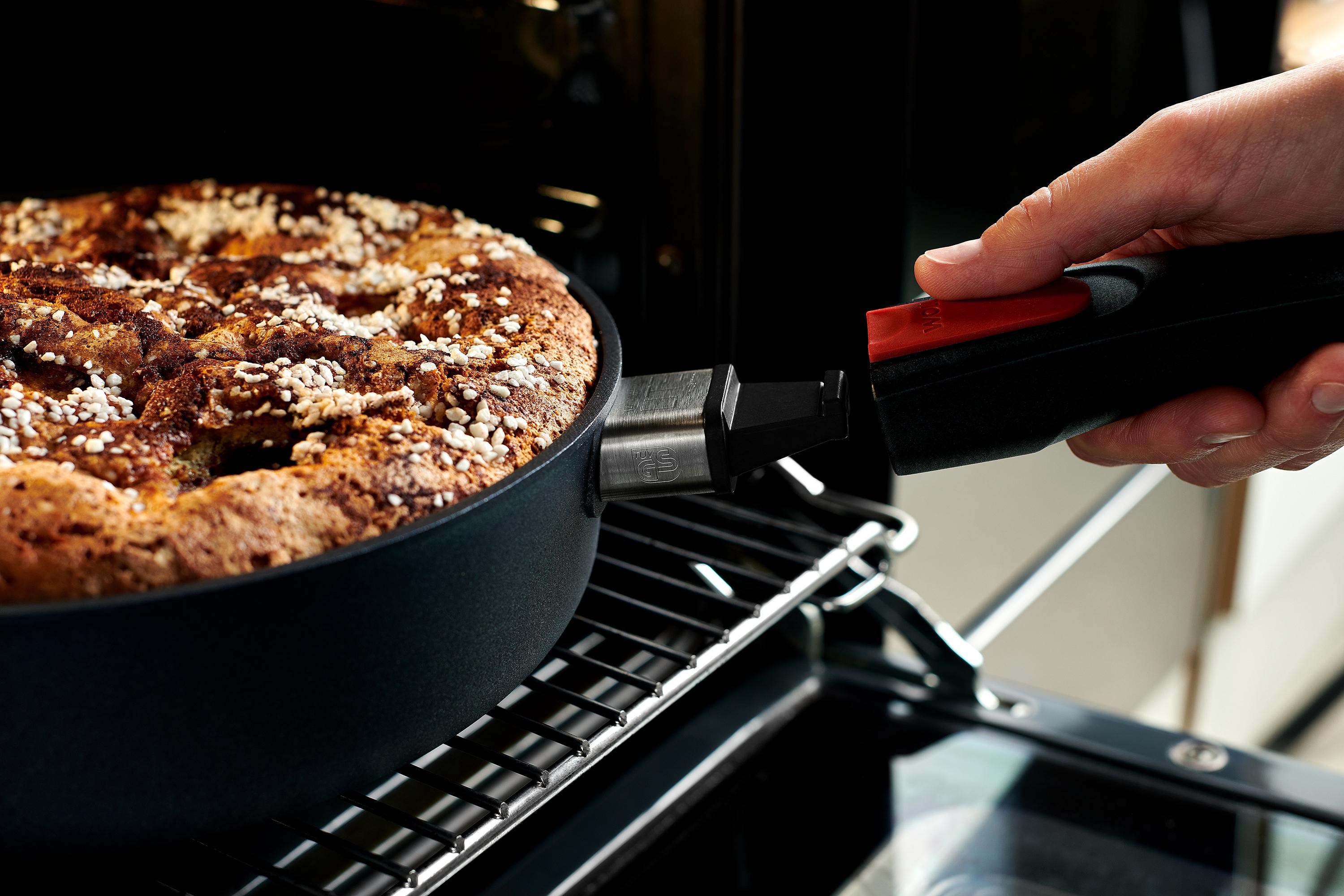 Auf dem Backofenrost steht eine runde Diamond-Lite-Pfanne mit einem gebackenen Kuchen. Um die Pfanne zu entnehmen, wird der Stiel eingerastet.