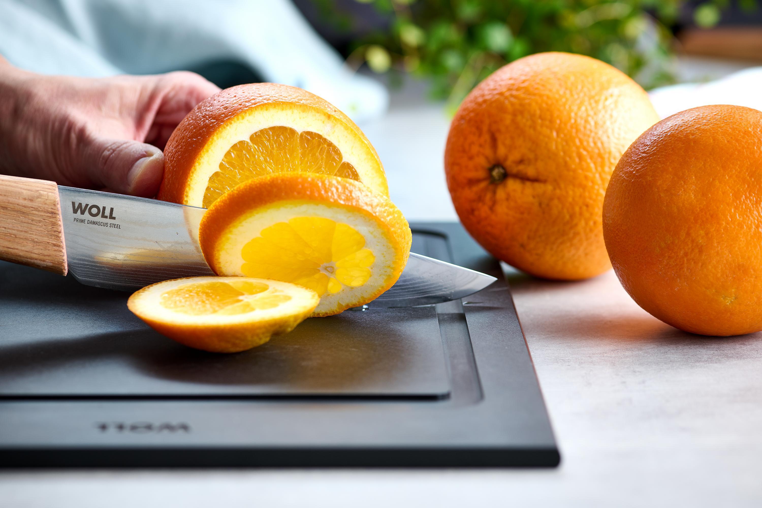 Prime Edge Kochmesser Kompakt Mit dem Prime Edge Kochmesser Kompakt wird eine Orange auf einem Schneidebrett in Scheiben geschnitten.