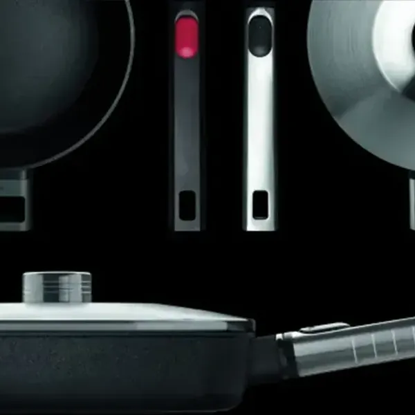 In der oberen linken Ecke ist ein Topf ohne Deckel aus der Serie Logic zu sehen. Daneben sind zwei verschiedene Stiele zu erkennen. In der oberen rechten Ecke ist eine runde Pfanne mit Deckel zu sehen. Darunter ist eine Pfanne mit Deckel und abnehmbarem S