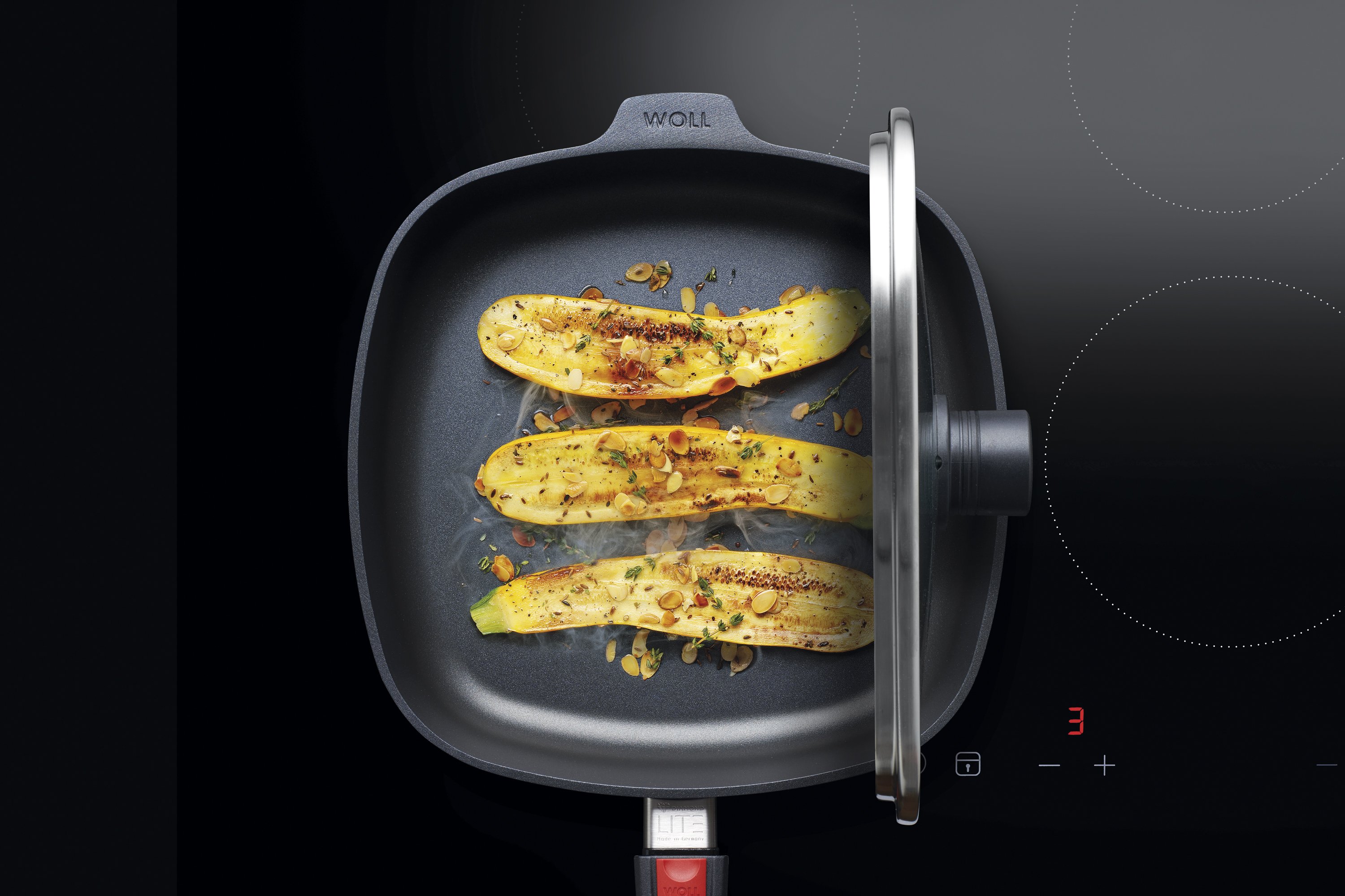 Smart Lid Sicherheitsglasdeckel, viereckig In einer viereckigen Diamond Lite Pfanne wird Gemüse angebraten. Der Smart Lid steht auf der Pfannenkante.