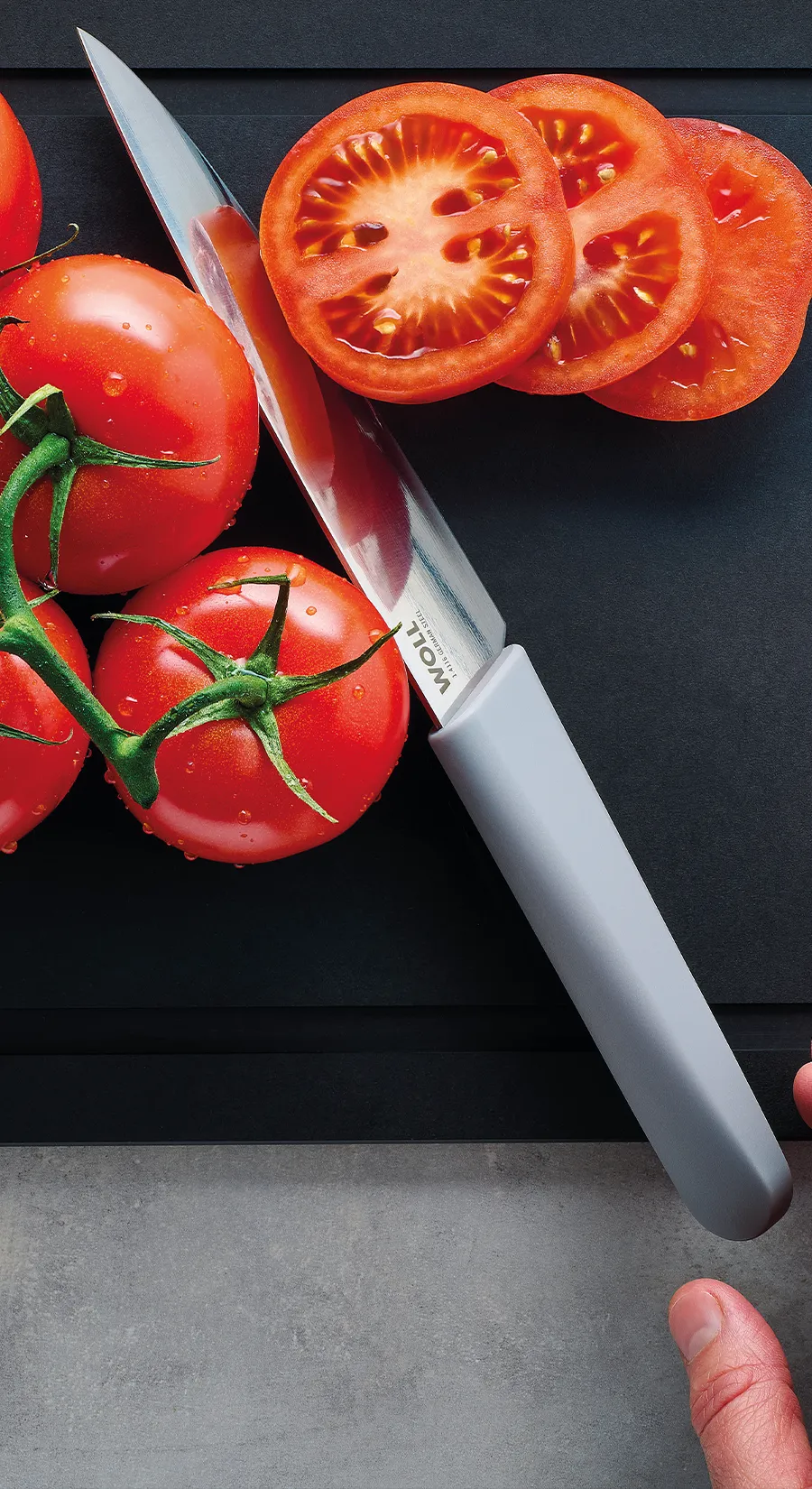 Mit dem Messer der Serie Cutting Edge werden mehrere Cherrytomaten auf einem Schneidebrett der Serie Cut & Serve halbiert.