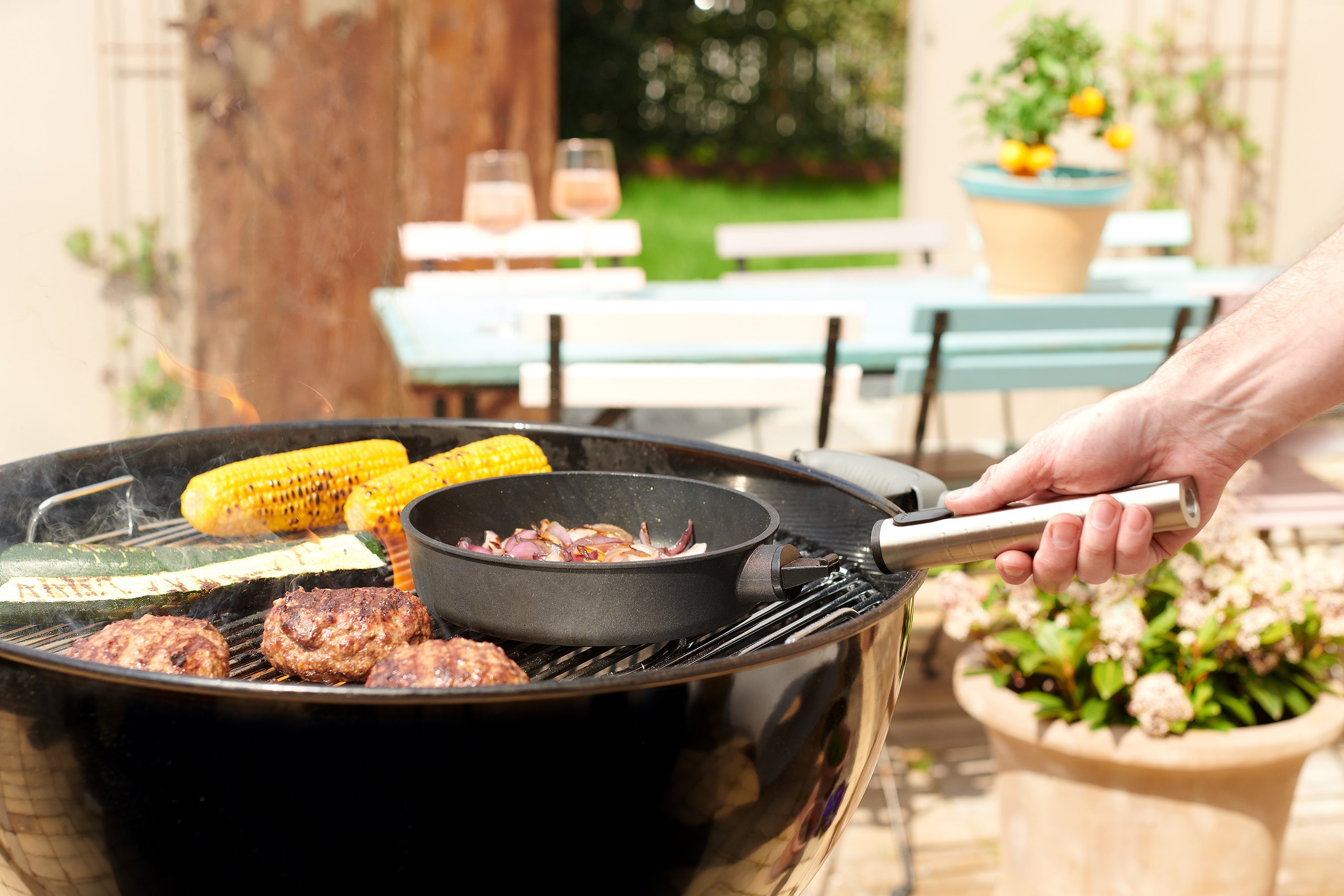 Eco Logic QXR Gusspfanne Auf dem Grill steht eine runde, gefüllte Logic XR Pfanne mit abgenommenem Stiel.